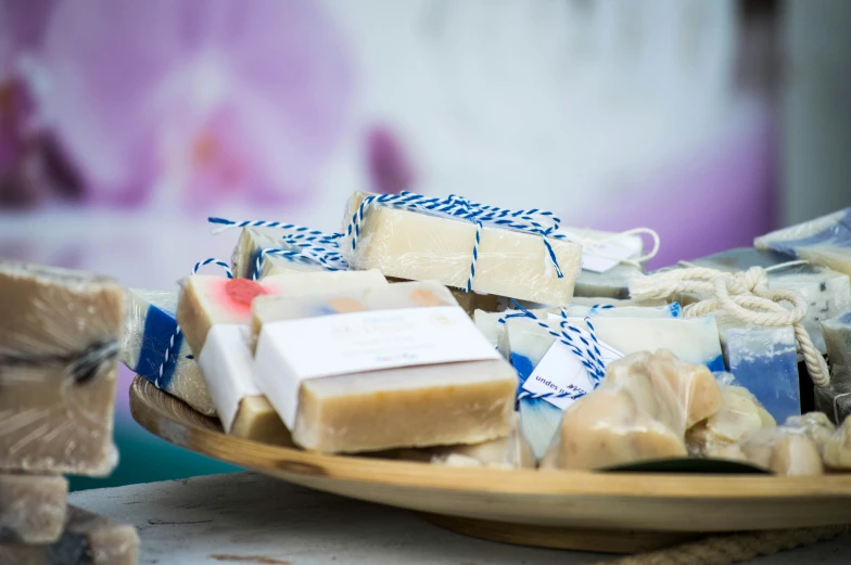 a wooden plate topped with lots of soap and bath items