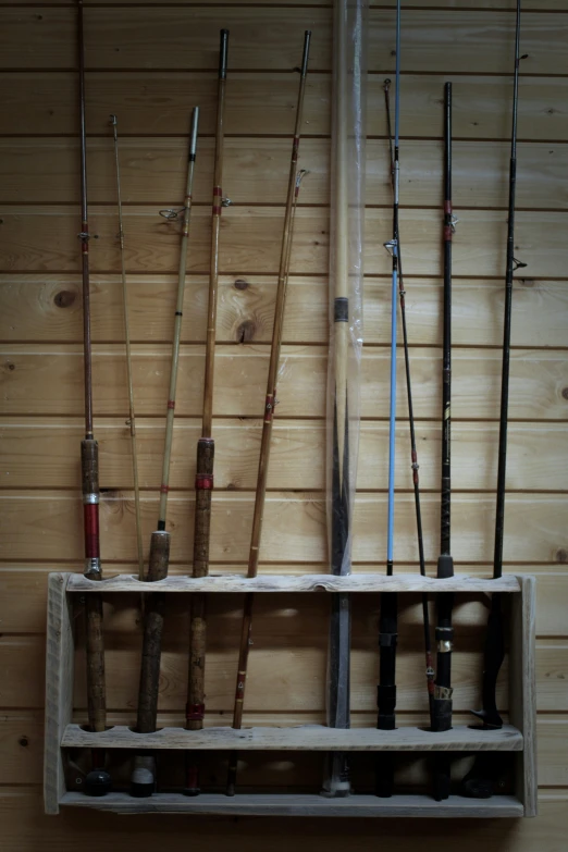 two wall shelves with fishing rods hanging on them