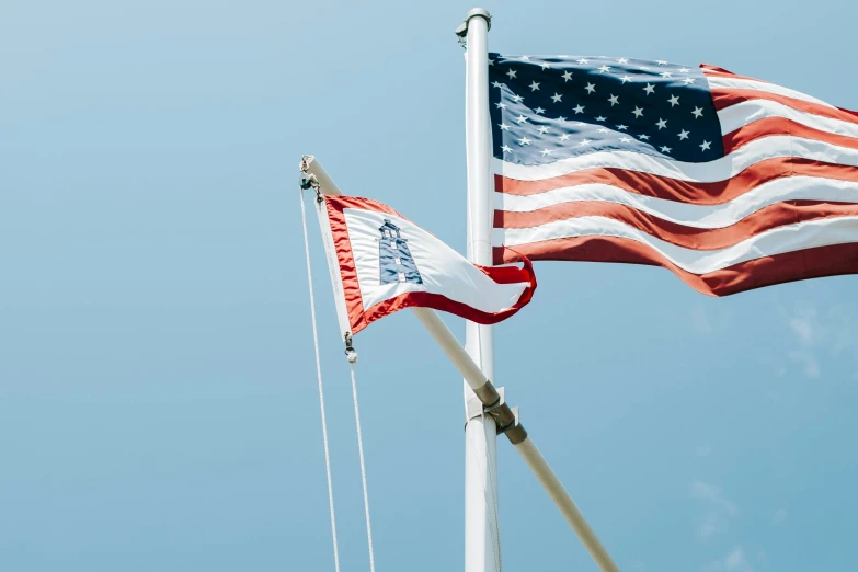 two american flags flying from one pole to the other