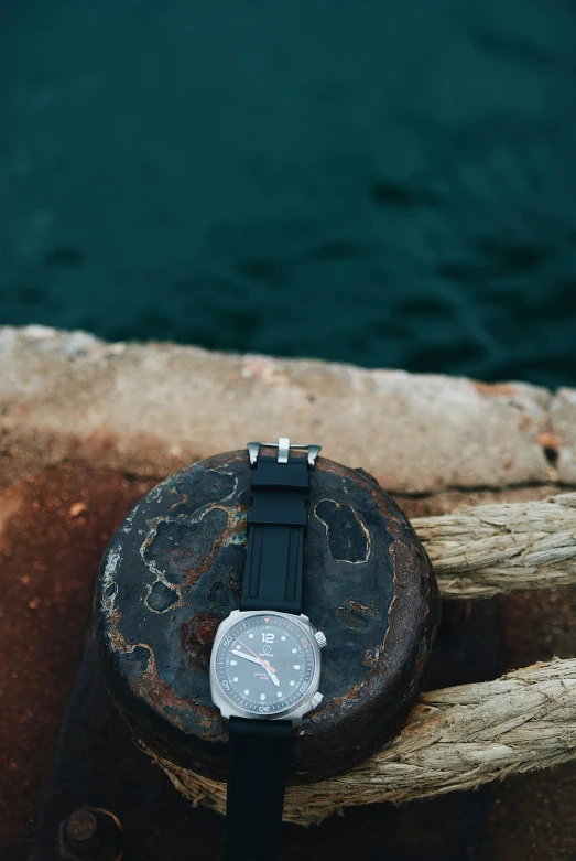 the watch is near the water on the rock