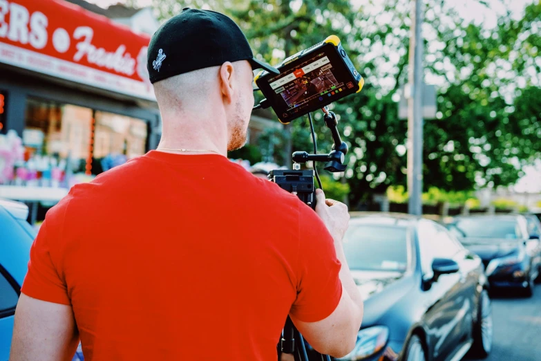 a man is taking a picture of a vehicle parked outside