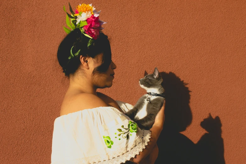 a girl in a dress holding a cat