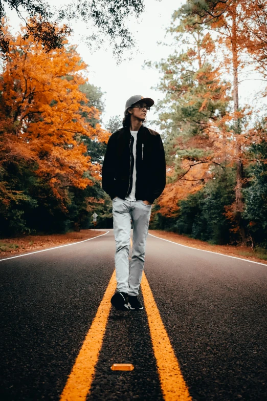 man in jacket and hat standing on yellow striped road