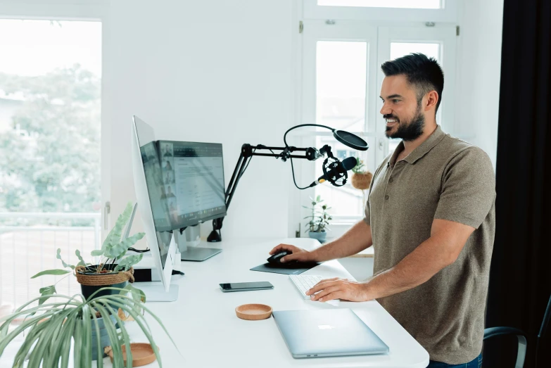 a man sitting at a desk using a computer in front of a desk with a mouse and tabletop