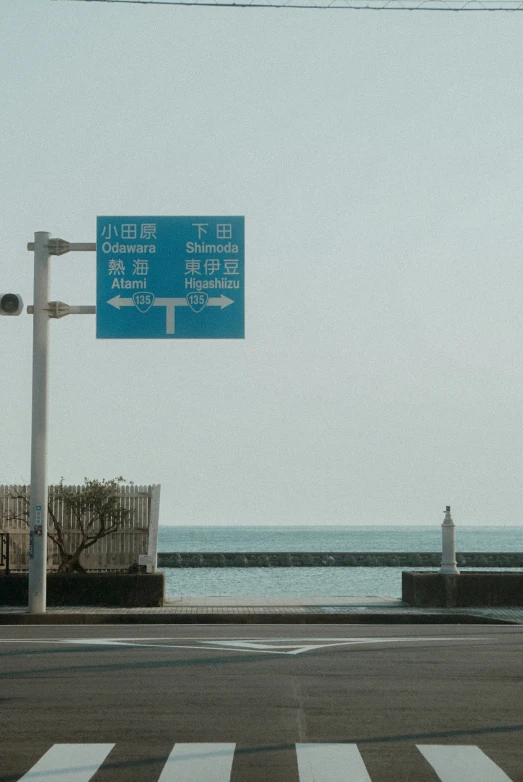 a blue sign and some signs by the ocean