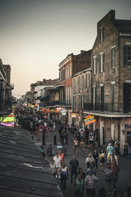 a crowd is walking down a busy city street