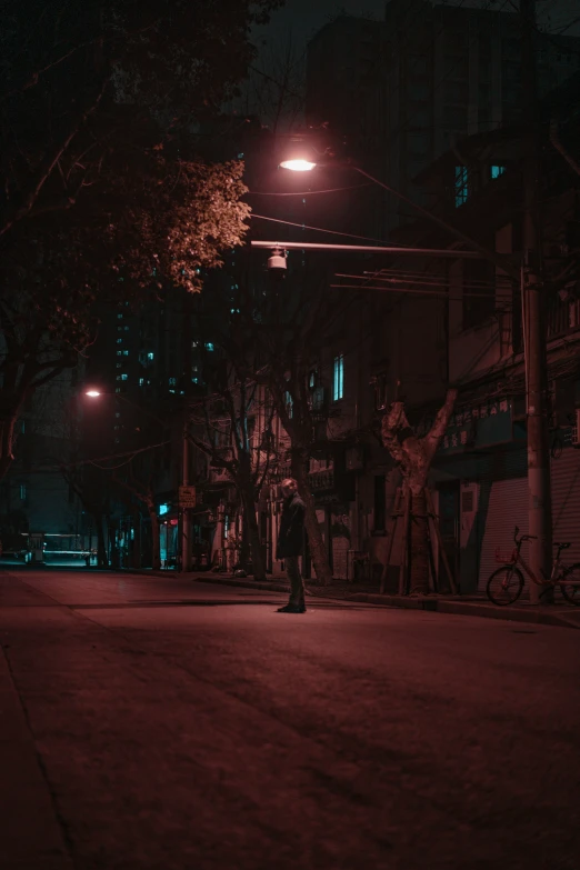 a man standing on the street corner at night