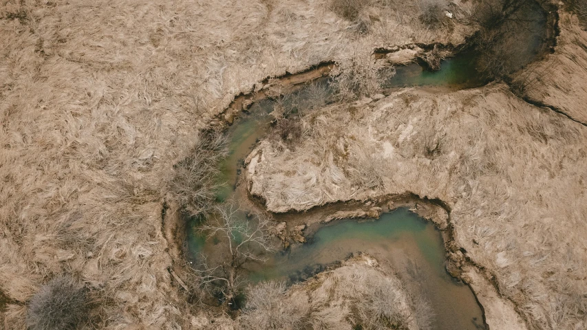 a stream of water flowing from a dirt hill