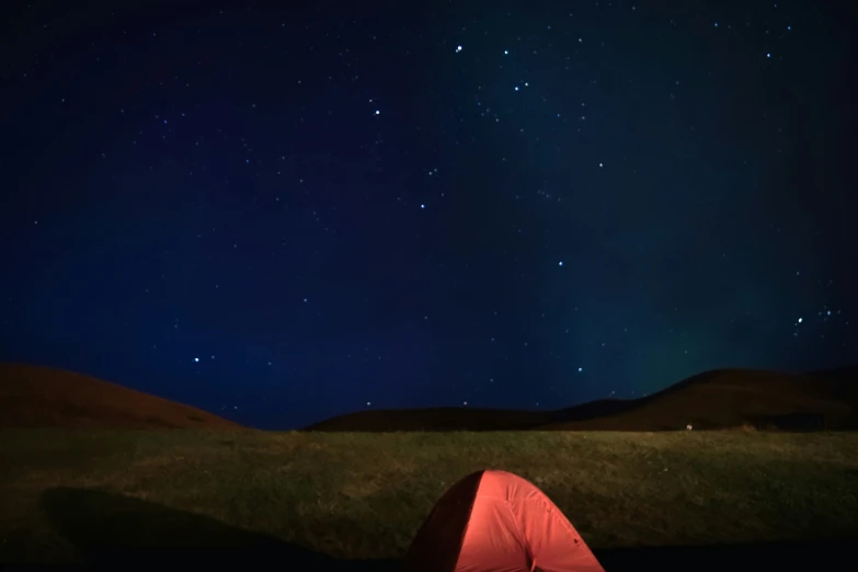 a camping tent is illuminated up at night