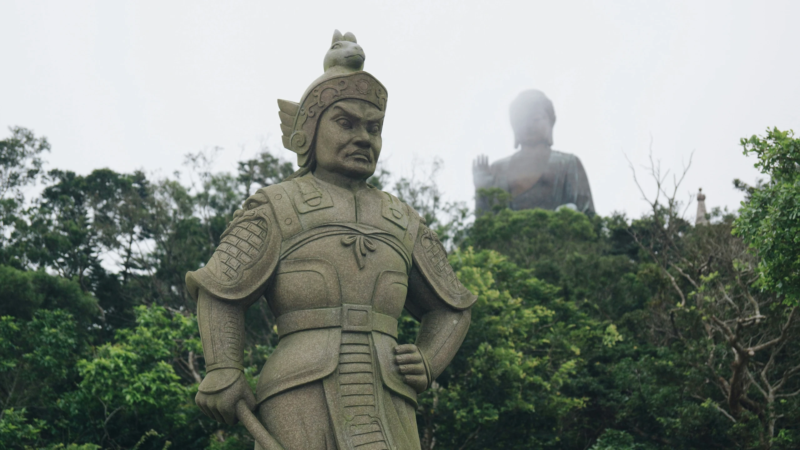 a statue of a soldier with a buddha statue behind it