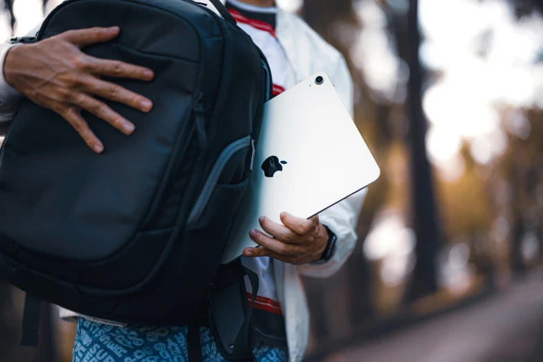 an older male carrying an ipad with a back pack on his shoulder