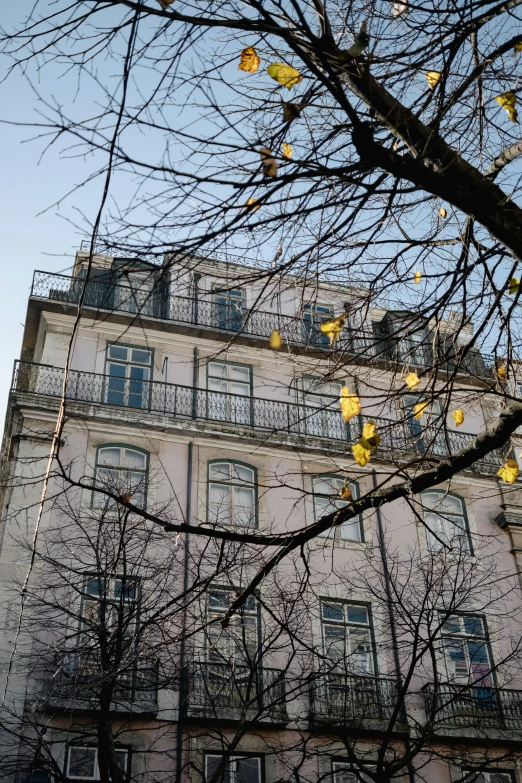 an apartment building has yellow lanterns strung on it