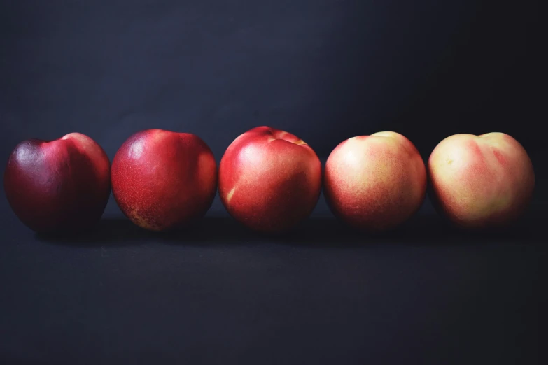 a group of four apples sitting next to each other