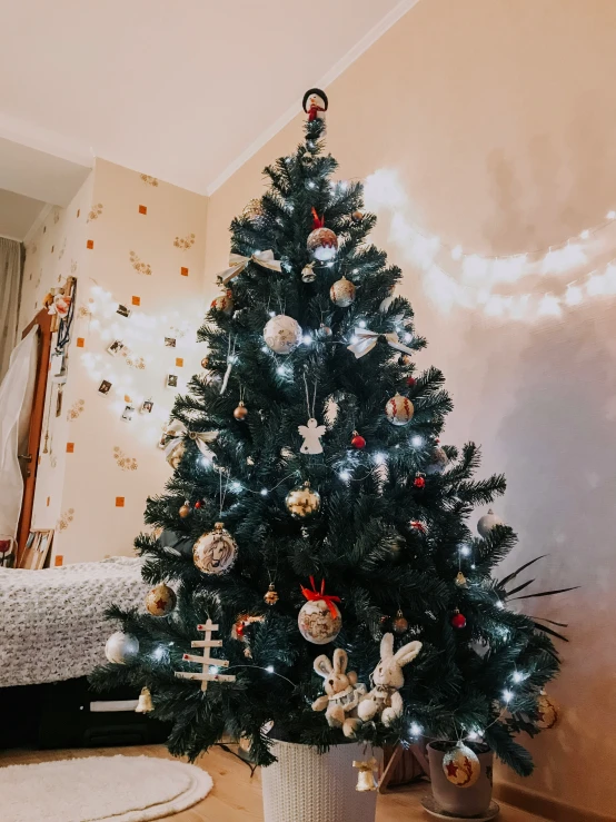 small artificial tree with ornaments on white pot
