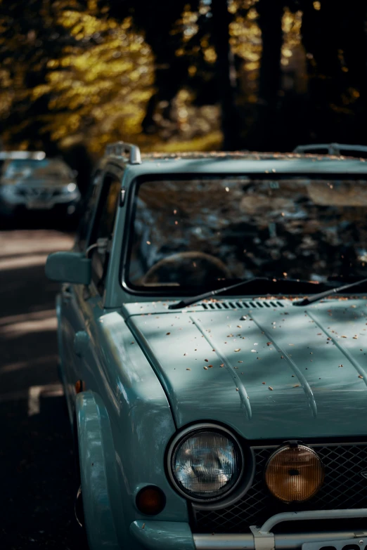 this old blue truck is parked in front of other cars