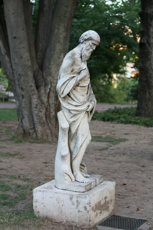 a statue is in a grassy area next to two trees