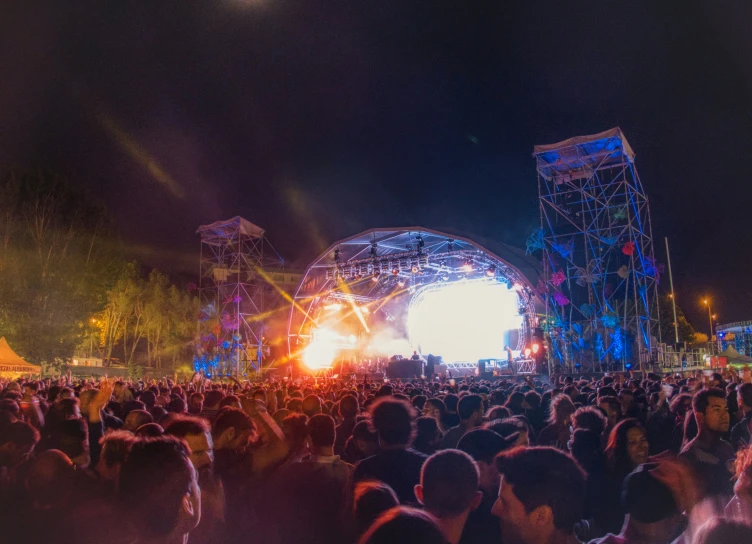 a crowd of people are standing in front of some stage lights