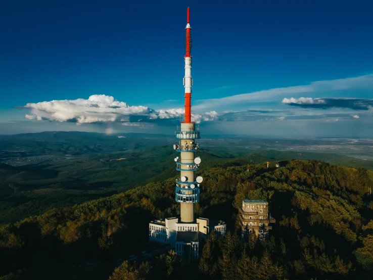 the tall, colorful tower has an antenna on top