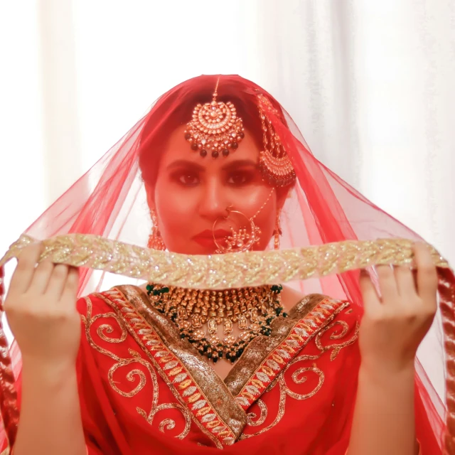 the woman with red hair and a veil has several gold jewelry on her head