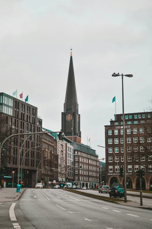 street in urban area with traffic passing by and steeple of building