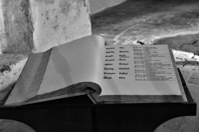 an open book on top of a wooden chair next to the water