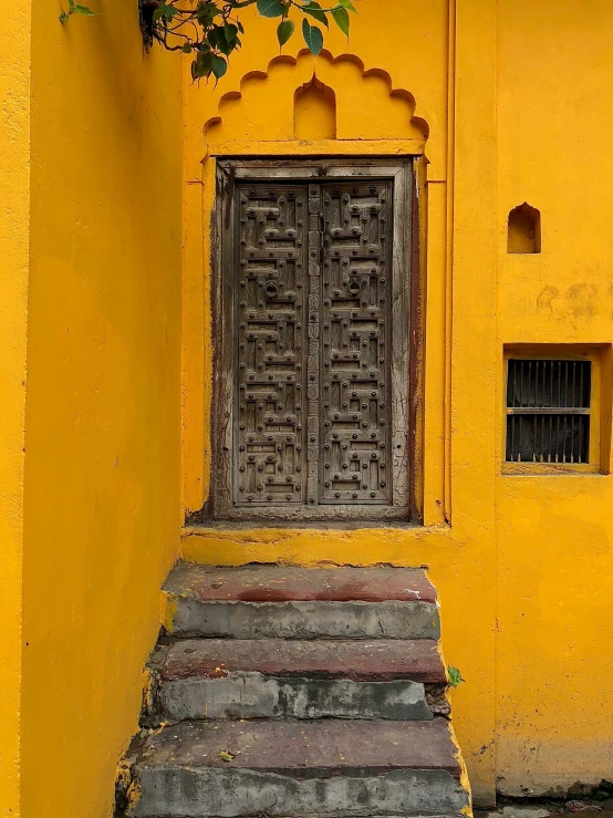 an old door that has been placed on an old yellow building