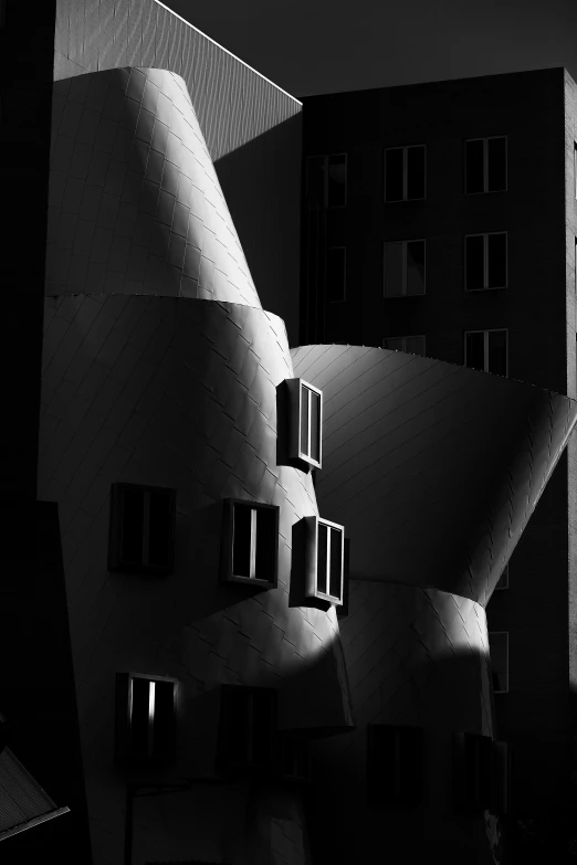 a building with multiple windows at night and light coming through it