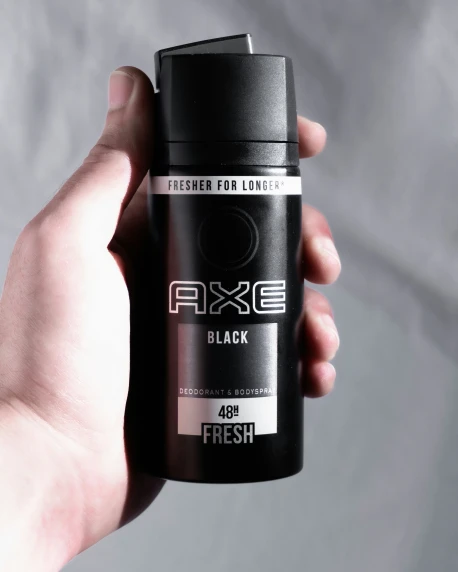 this is a male hand holding a black deodorant