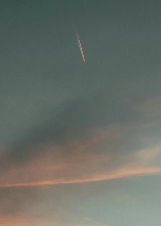 a plane flying overhead near the horizon at dusk