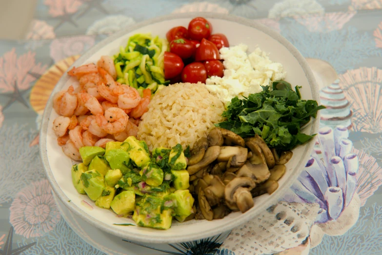 a plate of vegetables and shrimp is sitting on the table