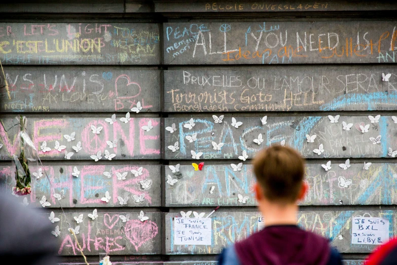 some children stand in front of a wall with writing