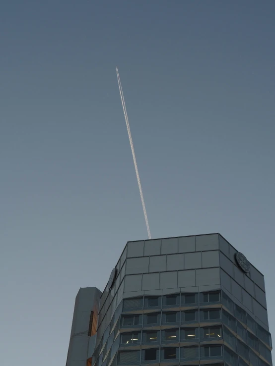 an airplane flying above an office building