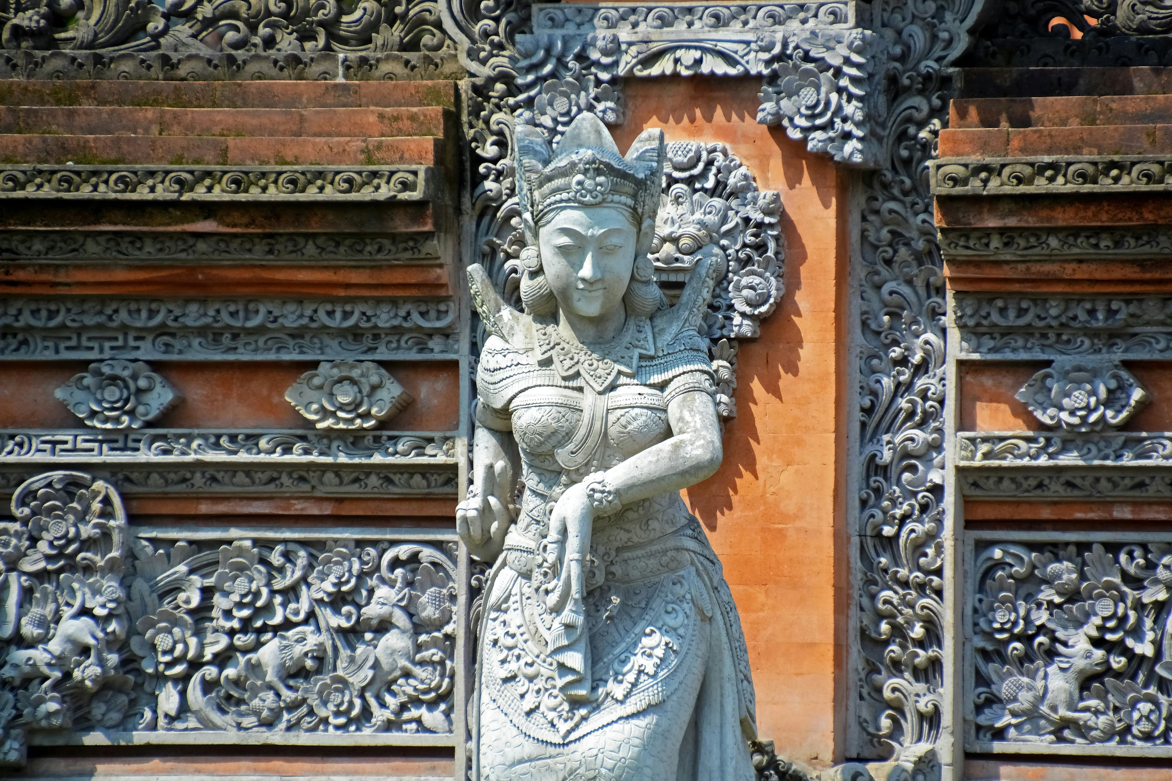 a statue stands on an ornate surface in front of a doorway