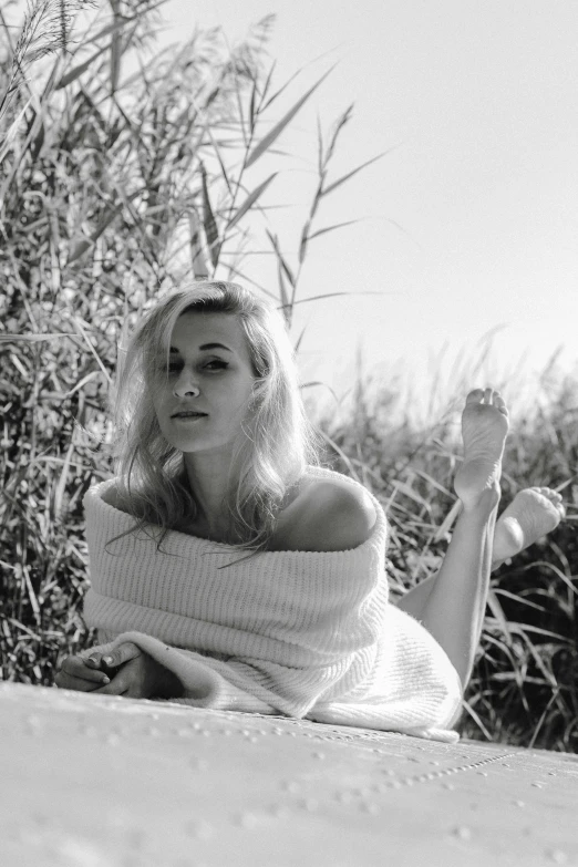 a woman with blonde hair laying in the grass