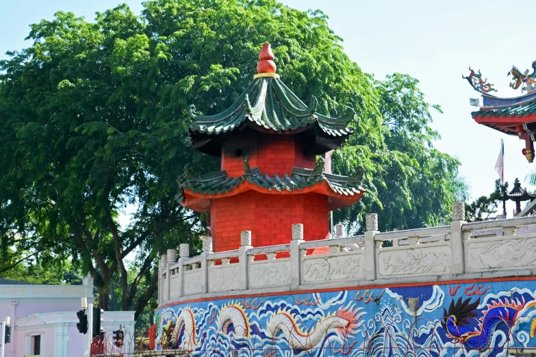a colorful asian pavilion sits behind a fence