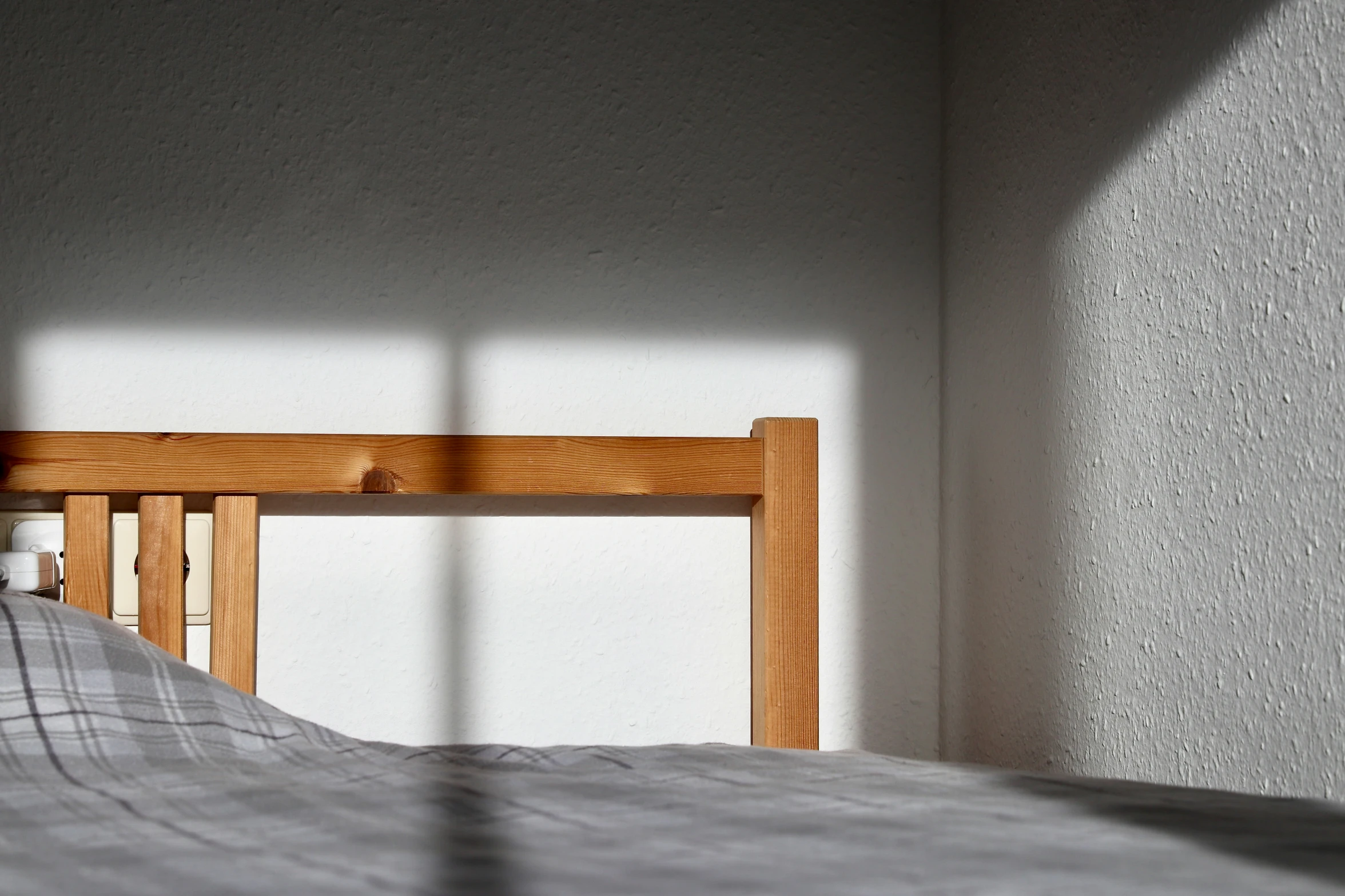 a bed with a shadow from the wall