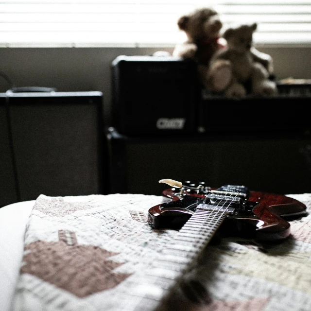 an electric guitar laying on the floor by a window