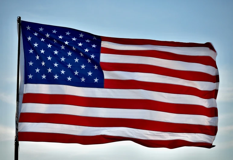 a flag flying in the air and a blue sky