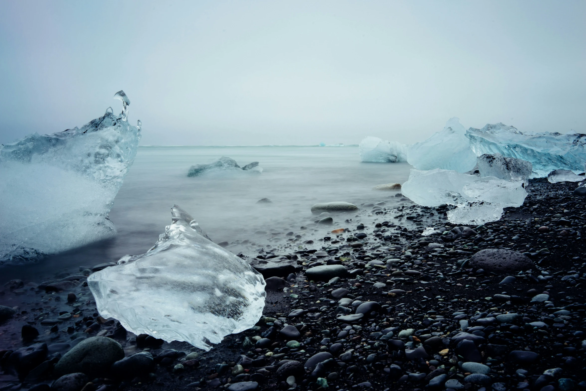 a beach covered with lots of ice and rocks