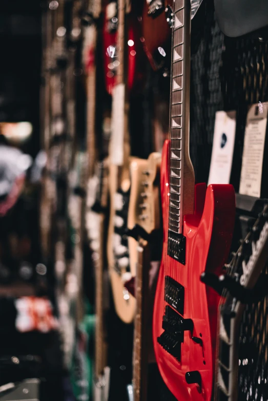 guitars hanging in a row and display with labels on them