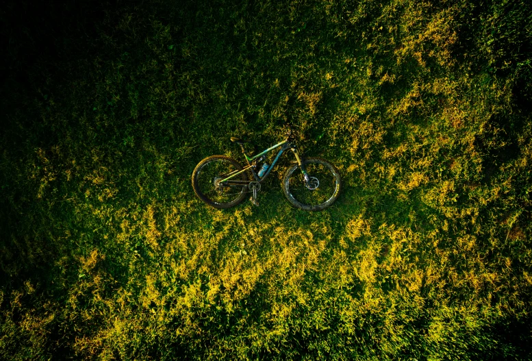 an aerial view of a bike in the middle of a green field