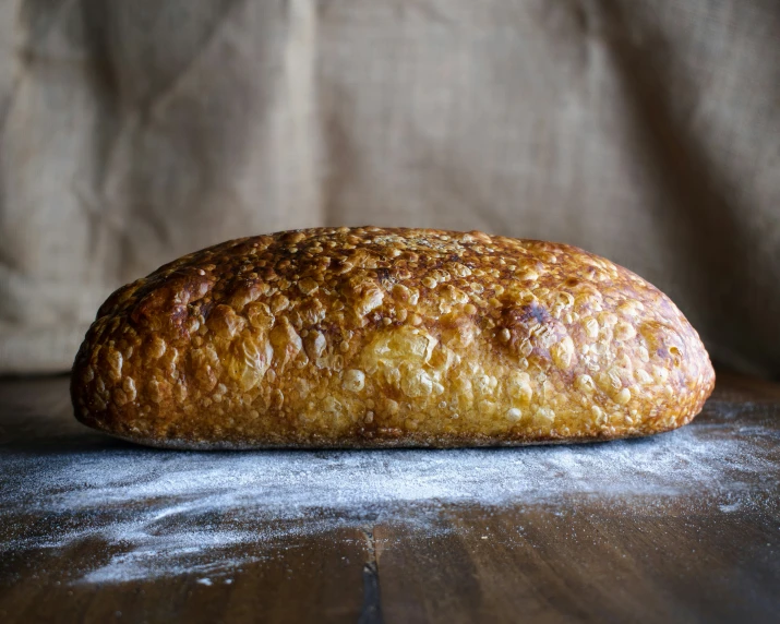 bread loaf on table with cloth in background