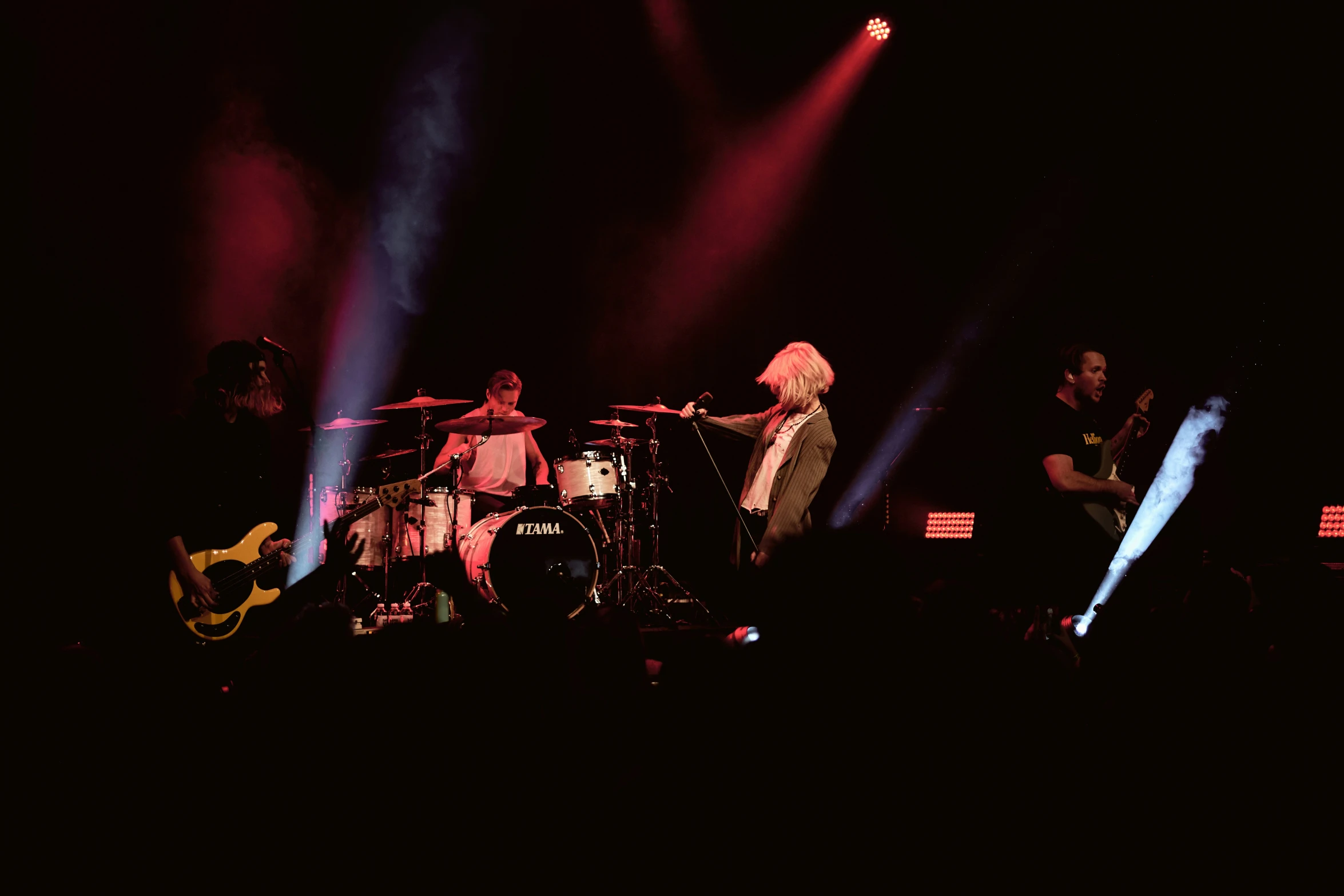 several people in silhouette on stage playing music