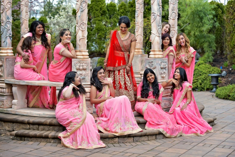 bride and bridesmaids in pink sarees and a man
