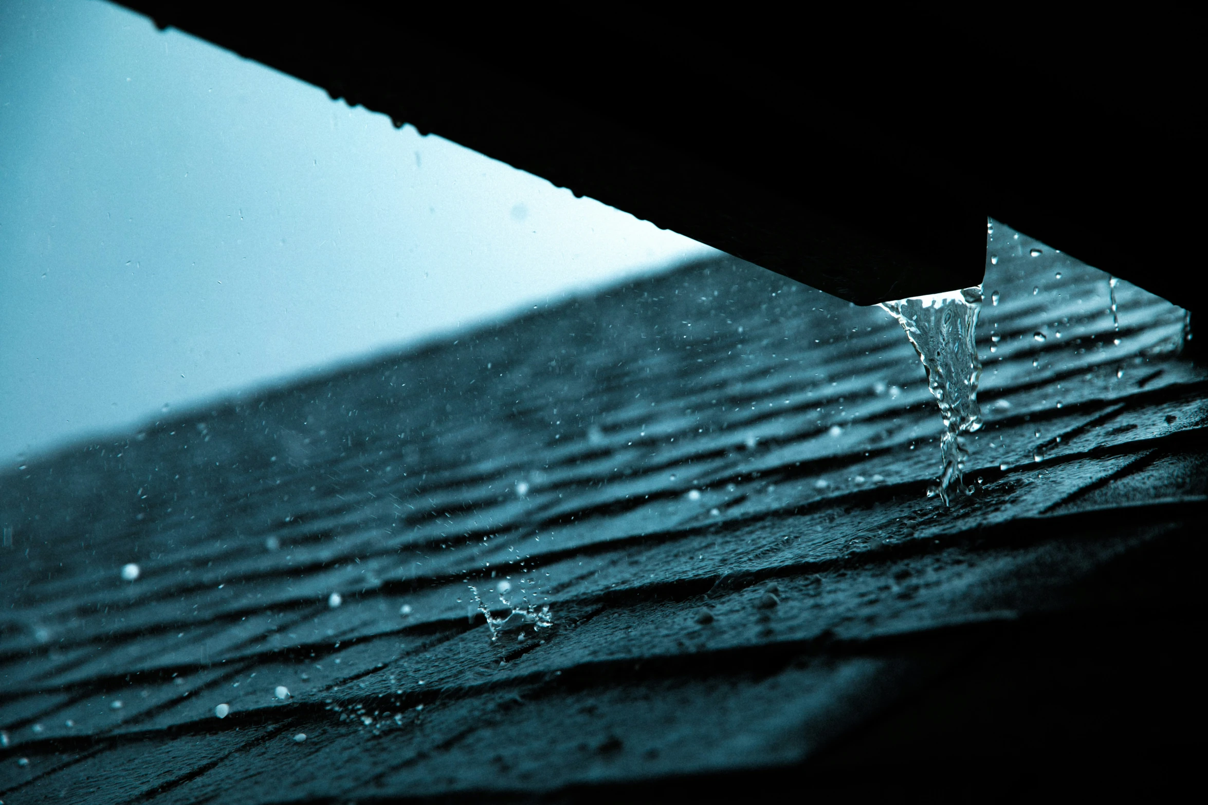 rain falling from an opened umbrella onto the roof