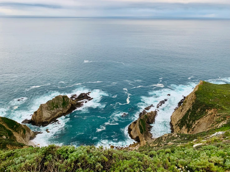 the view from the top of a mountain with ocean in the background