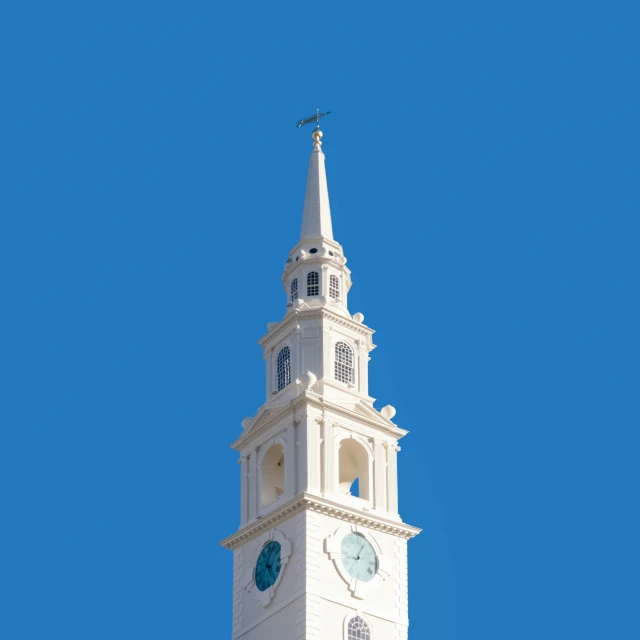 white steeple with blue clock on clear day