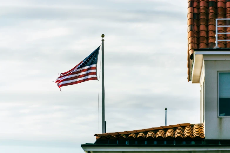 the american flag is flying above the windows