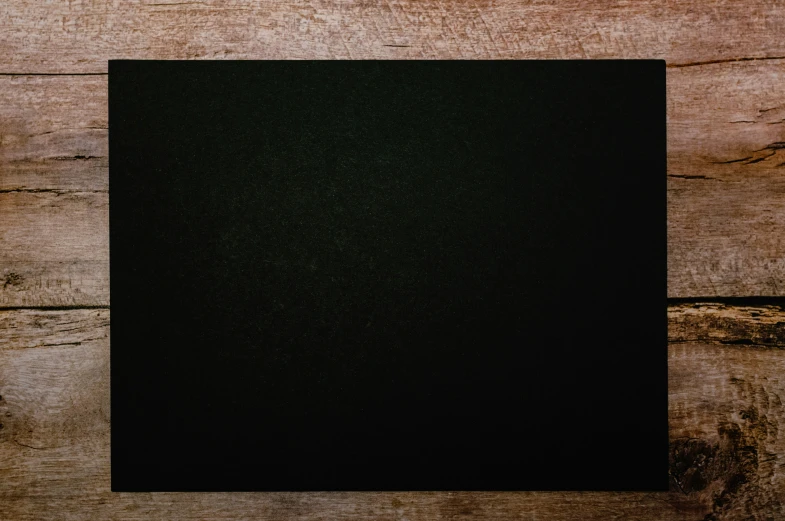 a black square on a wooden table with planks