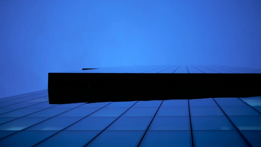an abstract pograph shows the side of a building with blue skies behind it